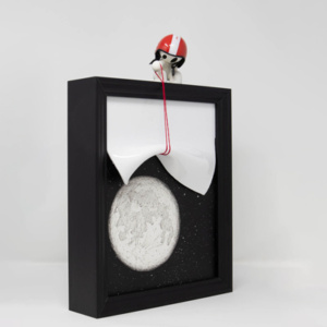original mixed media sculpture of a figure wearing a helmet lifting up a cover revealing the night sky and the moon illuminated by back lit lights by talented British artist Damilola Odusote